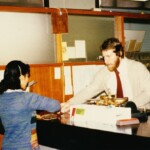 Mr Mike Allen behind the counter serving a customer at the Katanning Post Office